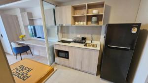 a small kitchen with a refrigerator and a sink at Cabanas Huahin by PTA in Hua Hin