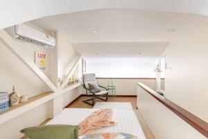 a small room with a bed and a chair at Nueng Rana 232 Corner view 1BR Duplex 3beds / 2B in Samphanthawong