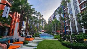 a courtyard with palm trees and a swimming pool in a building at Cabanas Huahin by PTA in Hua Hin