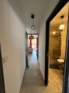 a hallway with a door leading to a bathroom at Le Relais des Cyclamens Bron in Bron +8 photos