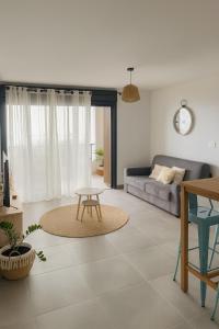 a living room with a couch and a table at Aurora Appart in Trois Bassins
