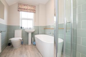 Un baño con bañera, inodoro y lavabo. en Central 2 BD Townhouse, en Stratford-upon-Avon 11 fotos más