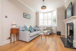 Una sala de estar con un sofá y una chimenea. en Central 2 BD Townhouse, en Stratford-upon-Avon