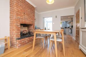cocina y comedor con chimenea de ladrillo en Central 2 BD Townhouse, en Stratford-upon-Avon