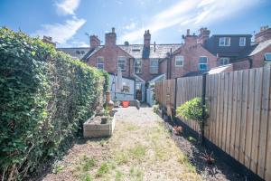 un patio trasero de una casa con una valla en Central 2 BD Townhouse, en Stratford-upon-Avon