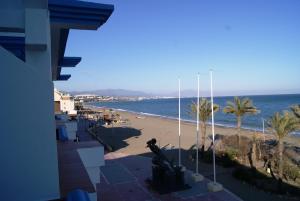 a view of a beach with palm trees and the ocean at Hotel Doña Luisa in San Luis de Sabinillas