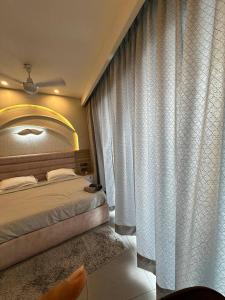 a bedroom with a bed and a large window at Supernova sky and river view heaven in Noida