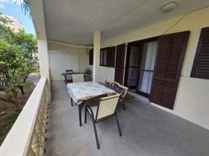 a patio with a table and chairs on a balcony at Apartman Antica in Komiža