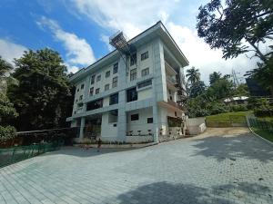 a large white building with a antenna on top of it at Moon Way in Neriyamangalam