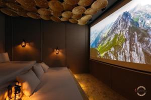 a room with a large screen with a bed and a tv at Al Tanoor House in Nizwa