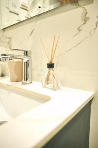 a glass vase with sticks in it sitting on a bathroom counter at 233 Boulevard by QUAO REALTY in Accra