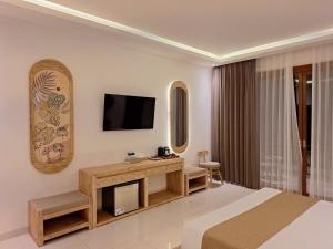 a hotel room with a bed and a television at Shakara in Ubud