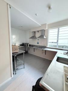 a large kitchen with white counters and a large window at Victoria Hostel in Rotorua