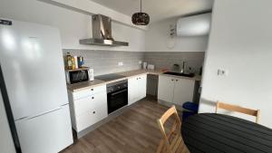 a small kitchen with white cabinets and a microwave at Casas de Valtravieso El Jardín in El Pozo de los Frailes +10 photos