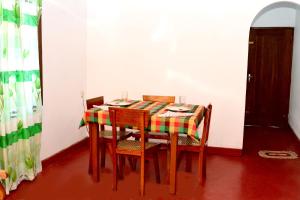 a table with four chairs and a colorful table cloth at Polhena Orchid Villa in Matara