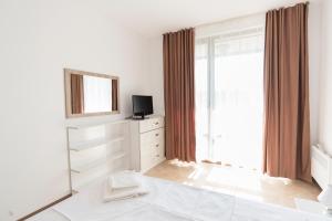 a white bedroom with a large window and a mirror at Oasis Resort & Spa Cozy Apartments in Lozenets +22 photos