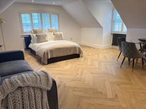 a bedroom with a bed and a wooden floor at Tranquil Tenterden Apartment Retreat in Tenterden