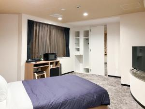 a bedroom with a bed and a television at Hotel LiVEMAX Naha Naminoue 1 in Naha