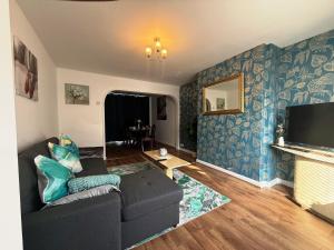 Exhallにある3 Bedroom House Near Arenaのソファとテレビのあるリビングルーム