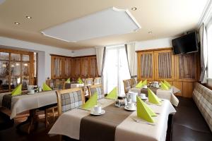 un ristorante con tavoli e sedie e un grande schermo di Hotel Garni Valülla a Ischgl