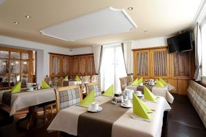 a restaurant with tables and chairs and a large screen at Hotel Garni Valülla in Ischgl