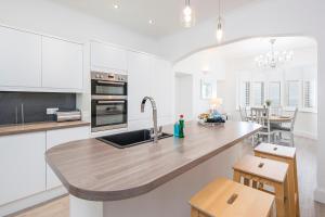 a kitchen with white cabinets and a wooden counter top at The Rath in Saundersfoot