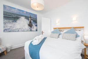 a bedroom with a bed with a picture of a lighthouse at The Rath in Saundersfoot