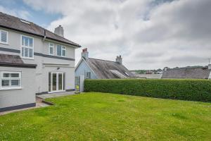 a house with a green lawn in the yard at The Rath in Saundersfoot