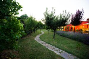 Un camino a través de un jardín con árboles y un edificio. en Coaching House, en Arezzo