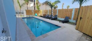 una piscina con sillas junto a una valla en Villas de Laguna 2, en South Padre Island