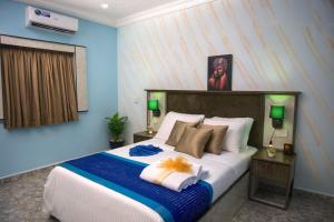 a bedroom with a large bed with blue walls at De-Manna Ota in Otta