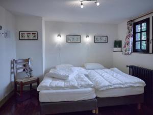 Un dormitorio con dos camas y una silla. en Spacious Villa in Liège, en Spa