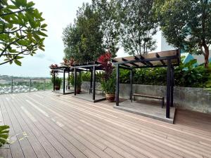 a wooden deck with benches and potted plants at Cosy Comfort Suite 3BR at Midas Seri Alam in Masai