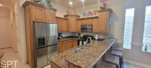 a kitchen with wooden cabinets and a stainless steel refrigerator at Island Time #4 in South Padre Island