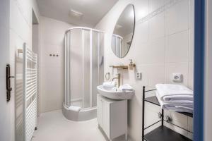 a white bathroom with a sink and a shower at Anmut by Revelton in Karlovy Vary +44 photos