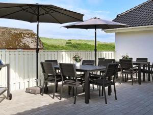 - une table et des chaises avec des parasols sur la terrasse dans l'établissement Luxury Spa Retreat by Sea - By Traum Ferienwohnungen, à Vrist