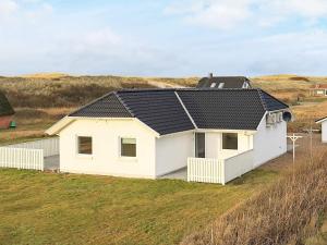 une maison blanche avec un toit noir sur un champ dans l'établissement Luxury Spa Retreat by Sea - By Traum Ferienwohnungen, à Vrist