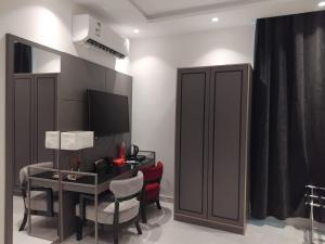 a room with a desk with a computer and a television at شقق ماجد حي الريان in Jeddah