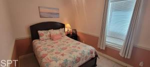 a bedroom with a bed with a floral bedspread and a window at Island Time #4 in South Padre Island +74 photos