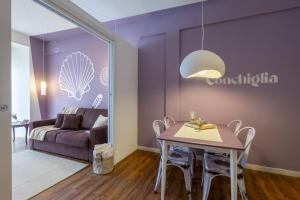 a living room with a table and a couch at Conchiglia design vista mare/spiaggia+parking in Diano Marina
