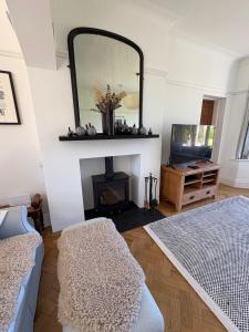 a living room with a mirror and a fireplace at Coastal Family Escape with Castle Views in Deganwy +24 photos