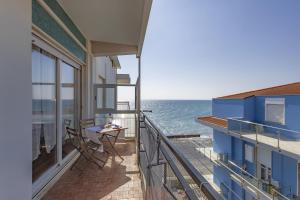 a balcony with a table and a view of the ocean at Conchiglia design vista mare/spiaggia+parking in Diano Marina