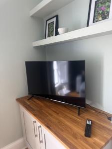a flat screen tv sitting on top of a cabinet at Serene Seaside Escape in Clevedon