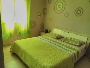 a bedroom with a green bed with two pillows at Apartment Tara in Sumartin