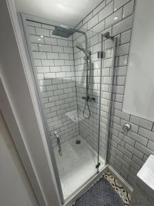 a shower with a glass door in a bathroom at Serene Seaside Escape in Clevedon +7 photos