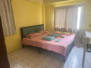 a bedroom with a bed with pink sheets and a fan at lin in Nadi