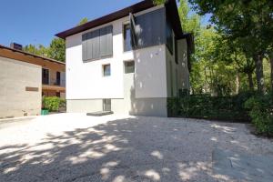 a white house with a large driveway at Le stanze di Caterina in Cesenatico