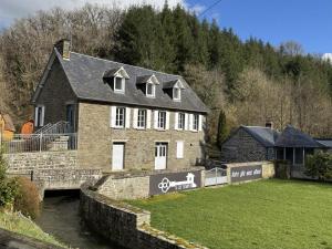 a large brick house next to a river at Moulin Harry 21 pers : 10 min Viaduc de la Souleuvre in Le Tourneur