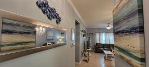 a hallway with a living room with a couch and paintings at Mar y Sol II #1 in South Padre Island