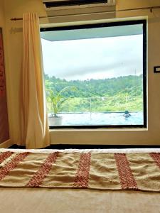 a bedroom with a window with a view of a pool at Valley Vista 3BHK Pool Villa in Igatpuri
